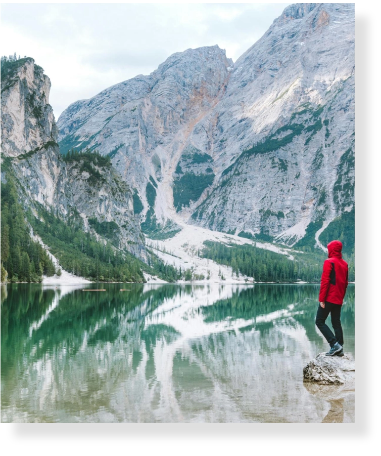 Person in red jacket looking at mountains.