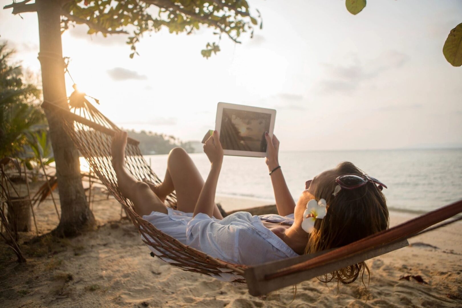 Woman relaxing in hammock on beach.