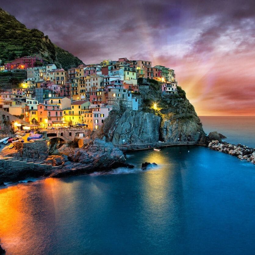 Coastal town at sunset with lights.